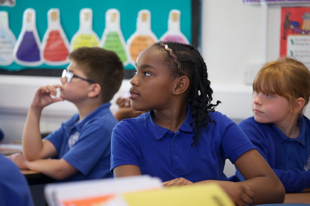 Child sitting at desk looking at teacher